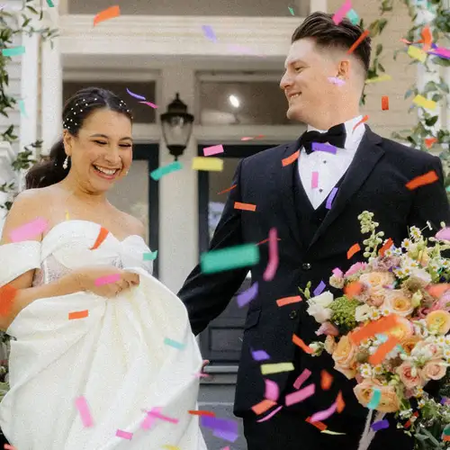 Bride and groom walking down steps with confetti falling